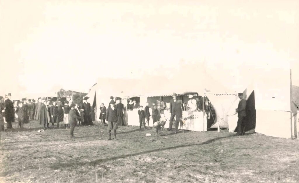 Historic outdoor gathering with tents.