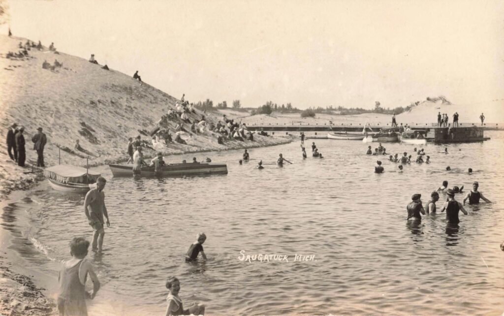 People swimming at a sandy beach.