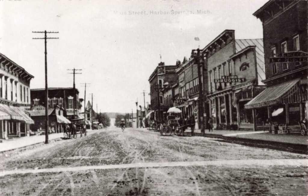 Historic street scene with horse-drawn carriages.
