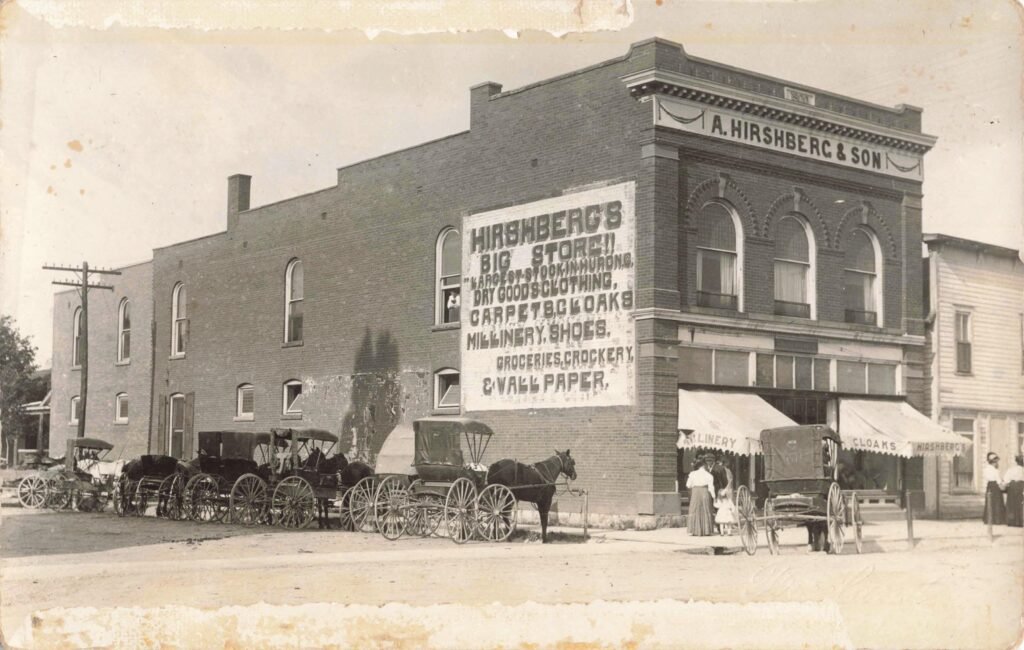 Historic storefront with horse-drawn carriages.