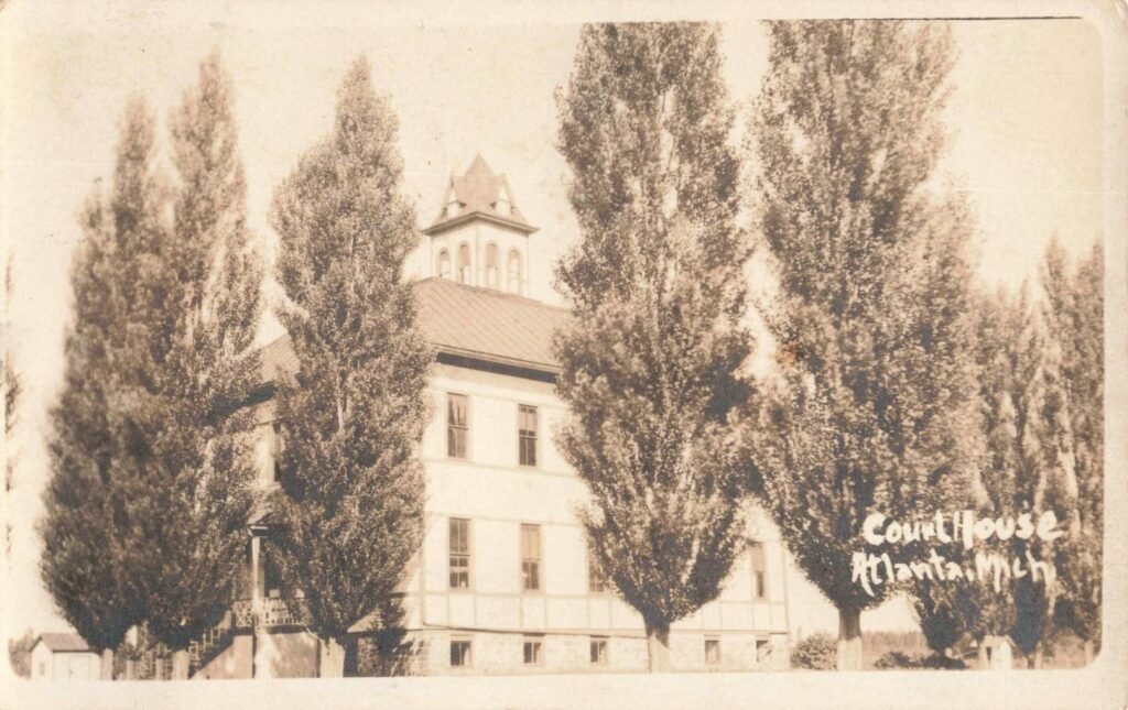 Historic courthouse surrounded by trees.