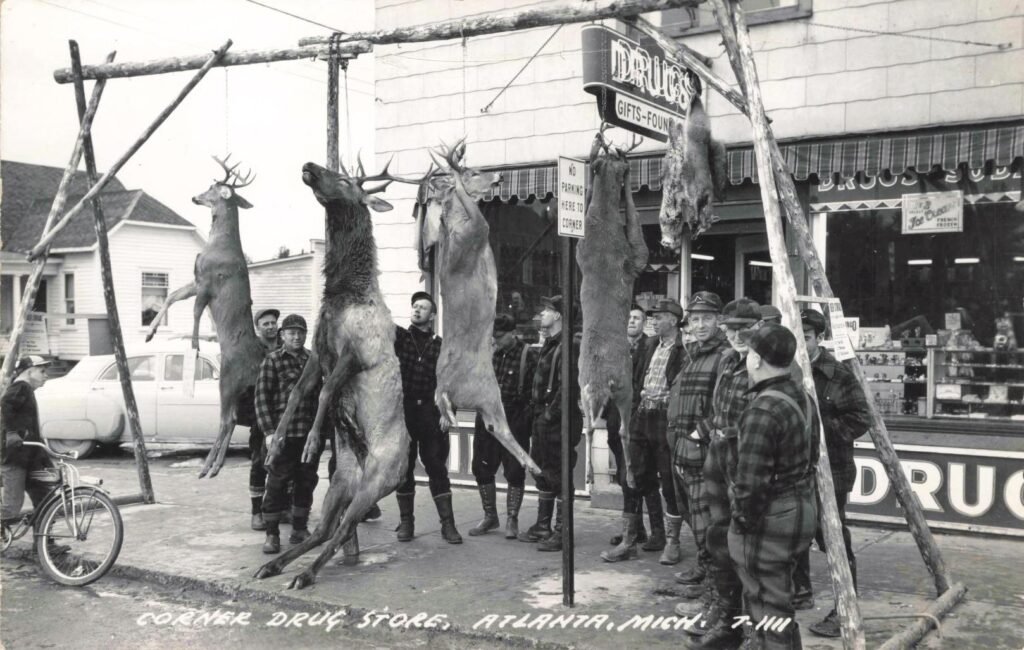Hunters displaying deer outside store.