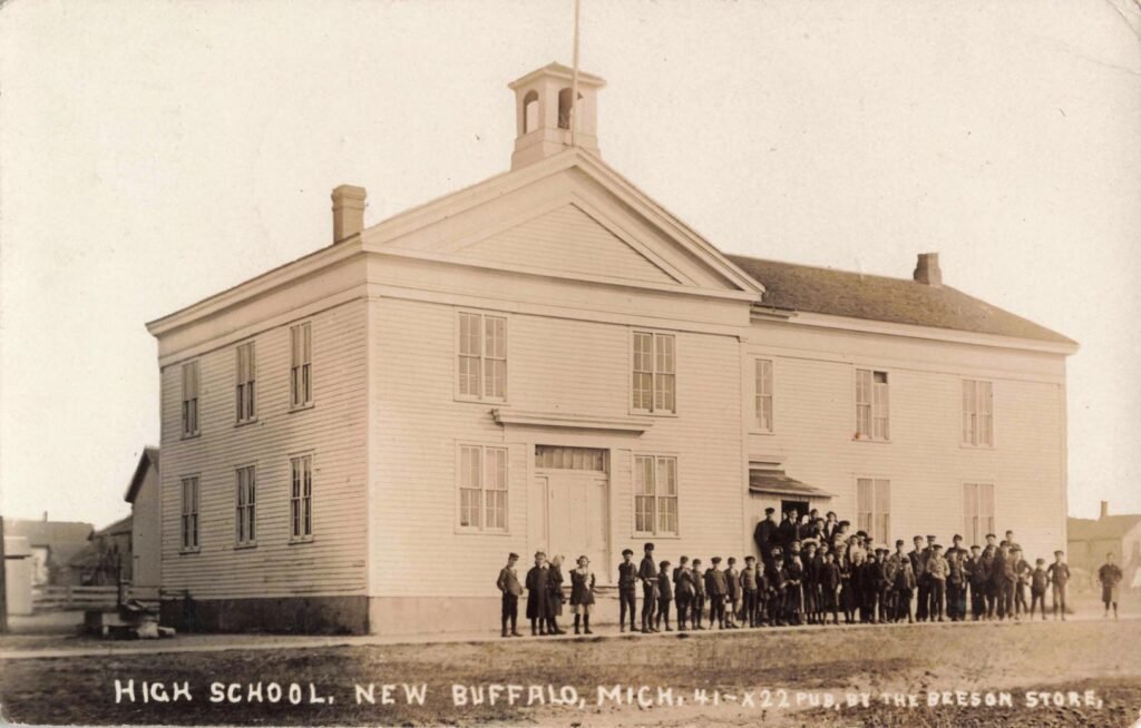 Historic high school with students gathered.