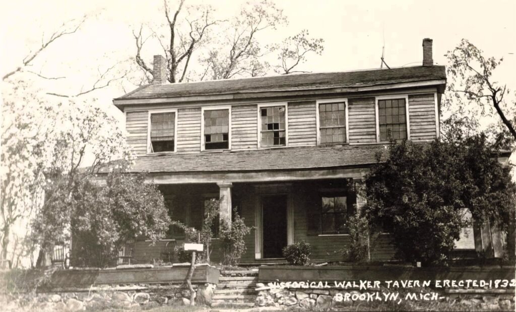 Historic tavern with porch and trees.