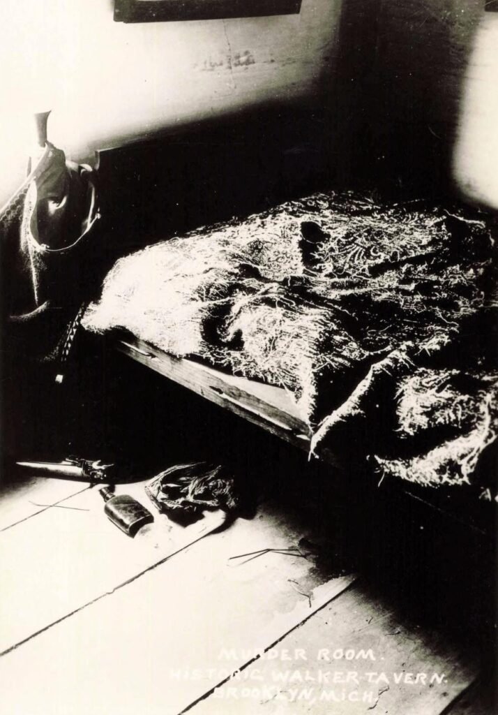 Dimly lit room with disheveled bed.