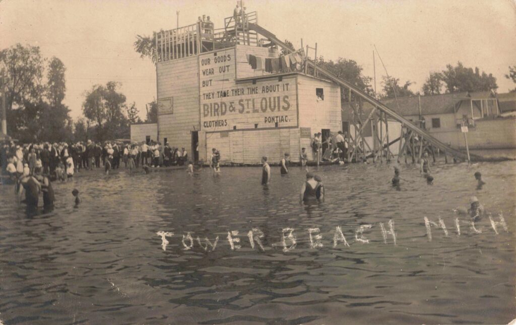 Vintage beach scene with people swimming.