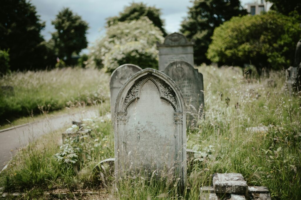 Overgrown cemetery with weathered gravestones.