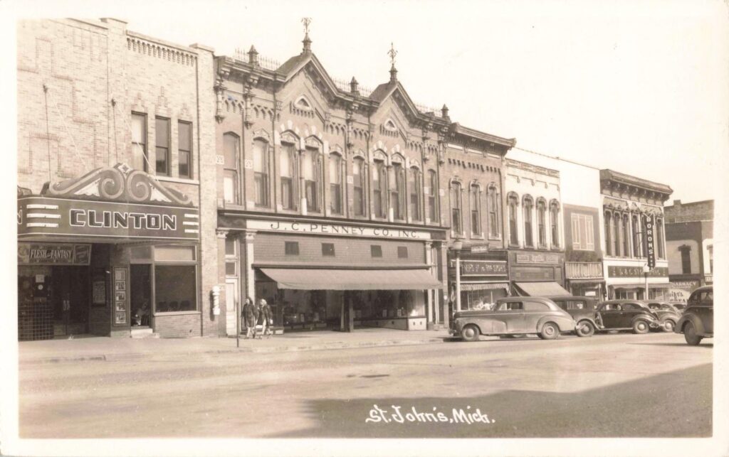Downtown St. Johns street scene with the Clinton Theatre, J.C. Penney storefront, and parked cars, circa mid-1930s