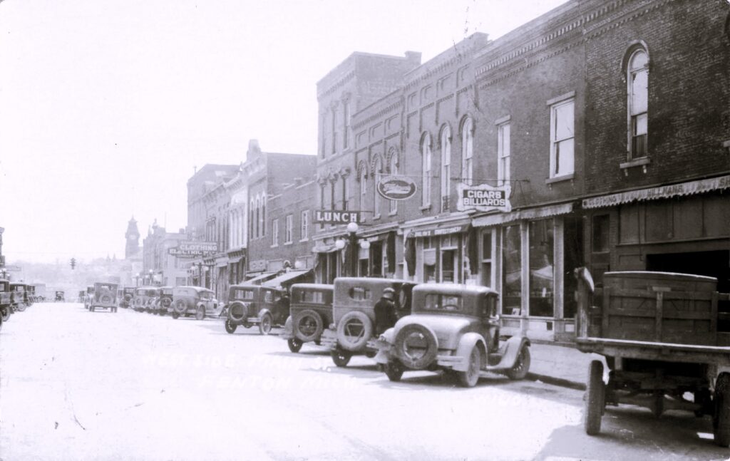 West Side Main Street view
A Main Street scene with automobiles and storefronts—daily commerce in an early twentieth century small town.