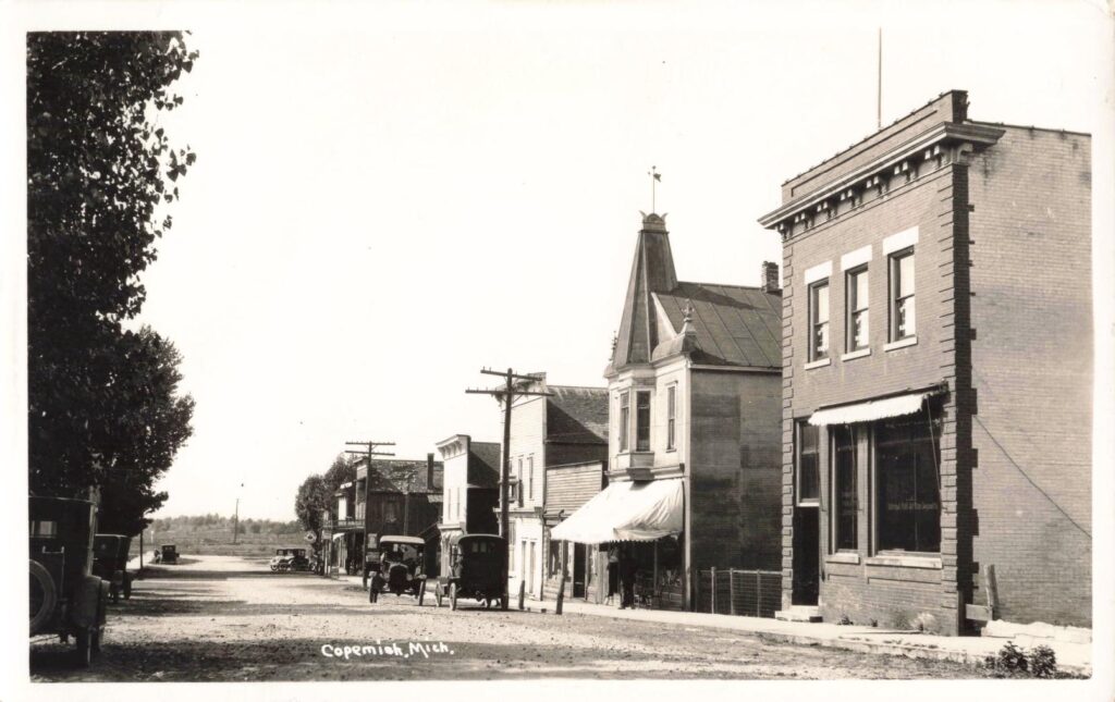 South Maple Street in Copemish showing commercial buildings and early automobiles.