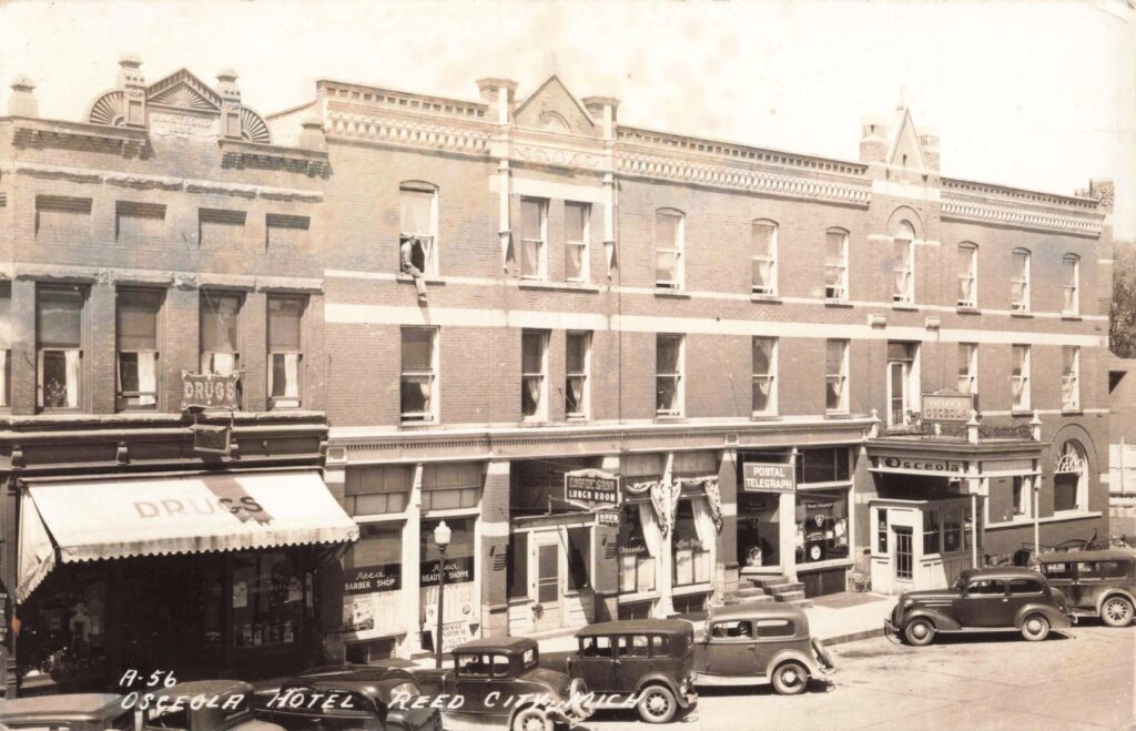 Historic hotel and storefronts, vintage cars.