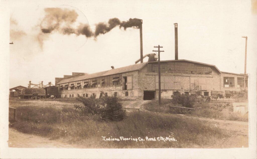 Historic factory with smokestacks and greenery.