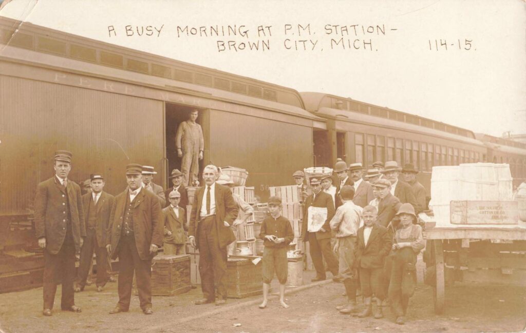 Busy train station with people and cargo.