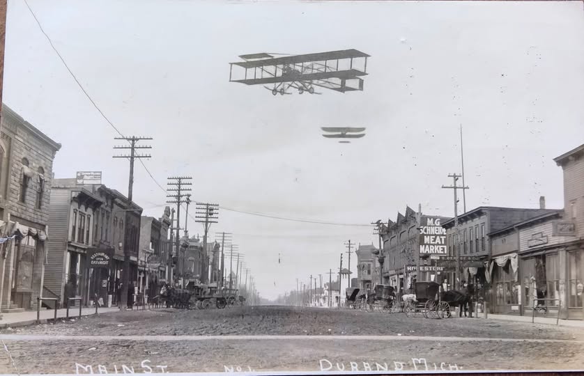 Historic street with early airplanes flying