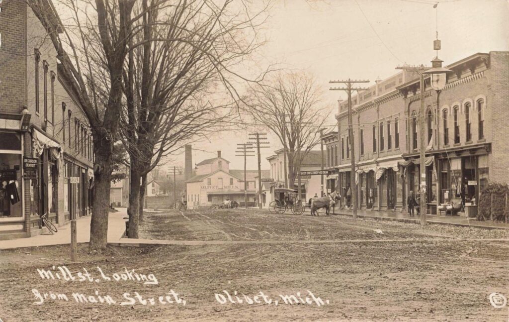 Historic street view with horse-drawn carriage.