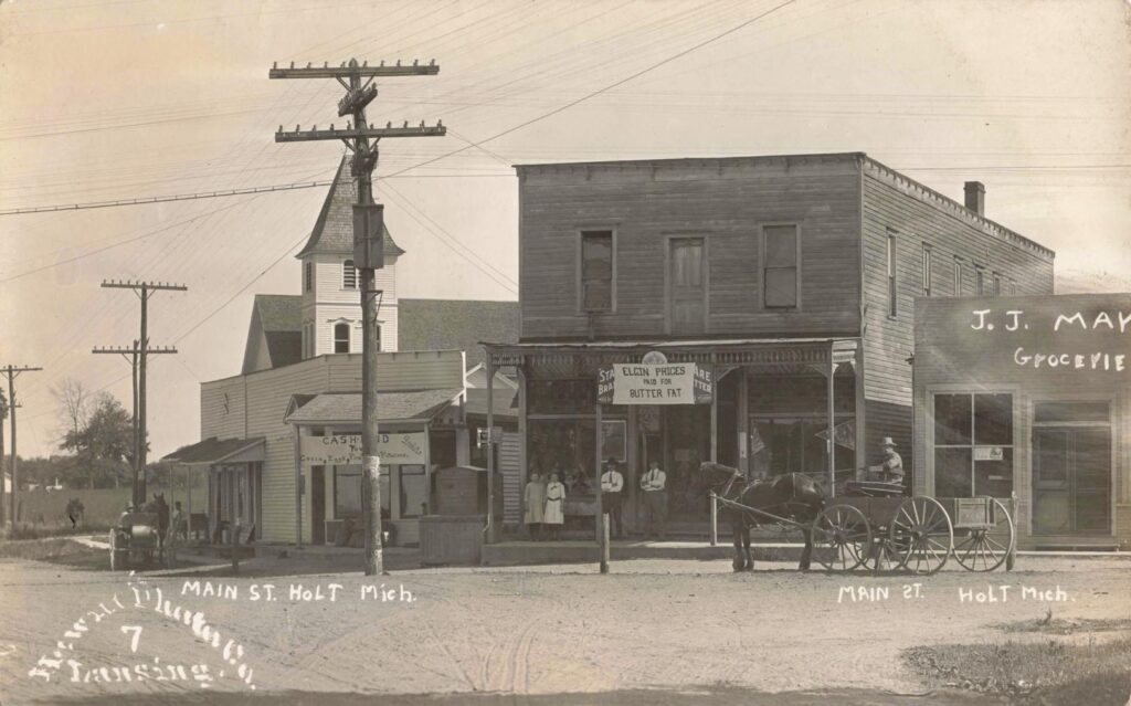 Main Street in Holt, Michigan, early 1900s, showing general stores, wagon traffic, and early utility lines that marked the town’s transition into a connected rural community.