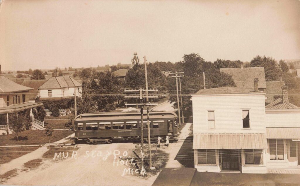 Historic streetcar near hotel and houses.