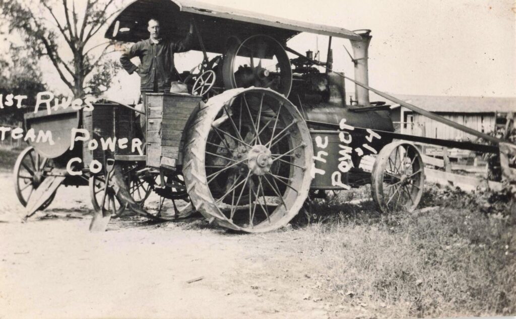 Old steam-powered tractor with operator