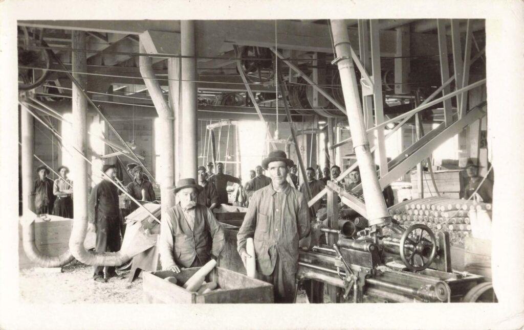 Historical factory with workers and machinery.