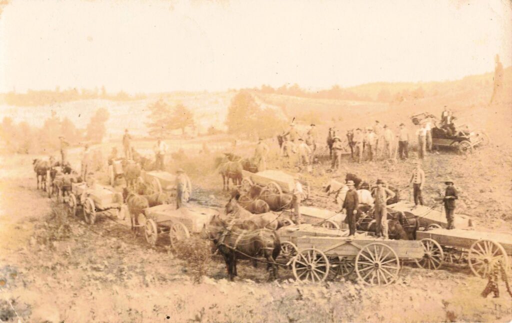 Historical farming scene with horse-drawn wagons.