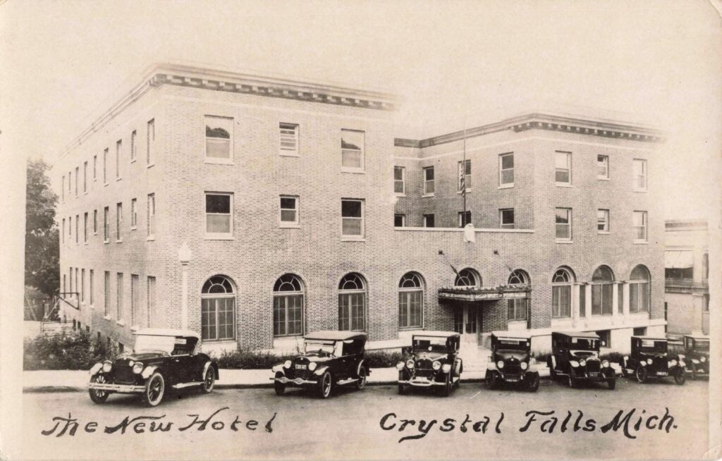 Historic hotel with vintage cars outside.