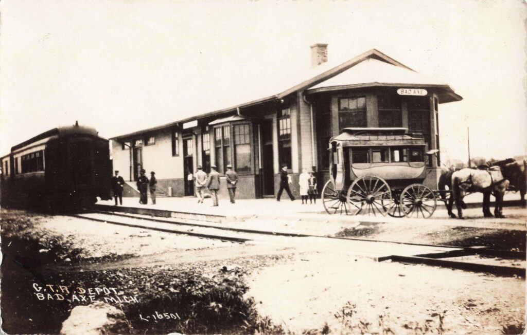 Grand Trunk depot and rail coach.. Railroad links let Bad Axe operate as more than a local stop; they tied the town to larger trade and travel routes.
