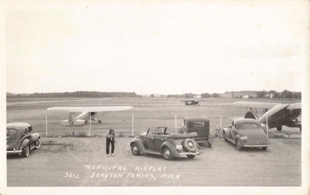 Vintage airport scene with classic cars