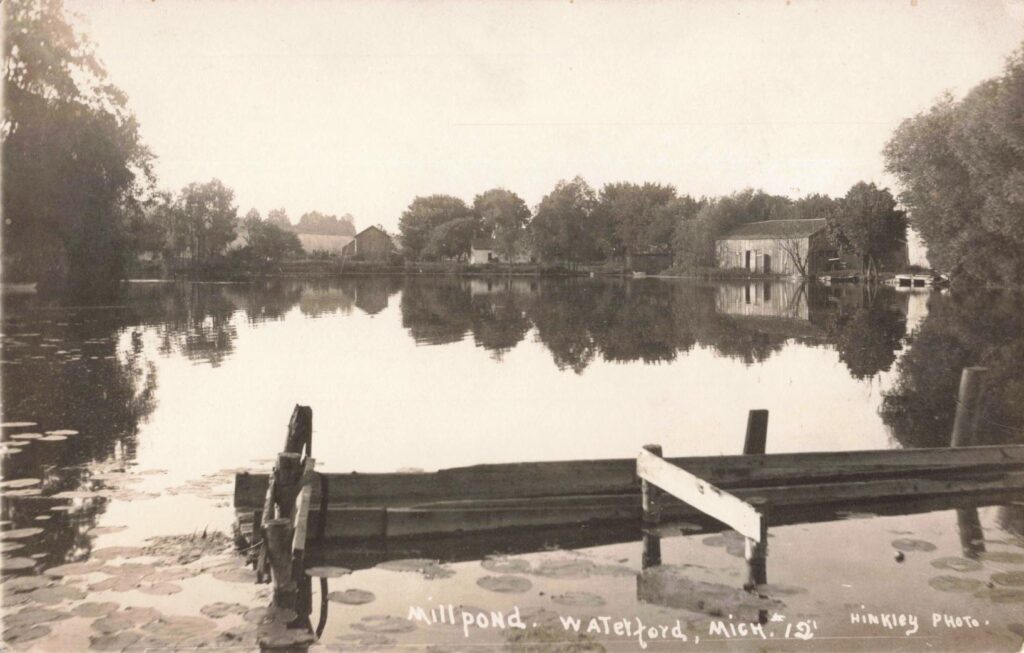 Serene pond reflecting surrounding trees. - history of waterford Michigan