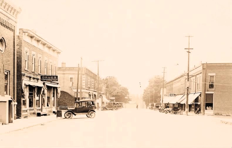 Main Street, Concord, Mich. — Horses, wagons, storefronts and early automobiles show the village crossing into the motor age.