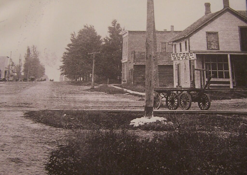  Deford Hotel, 1912. Local directories listed Hotel McCain as “The Traveler’s Home,” and later notices show the hotel used for public business, not only lodging. Its location near the railroad made it a logical stop for salesmen, buyers, and rail travelers. 