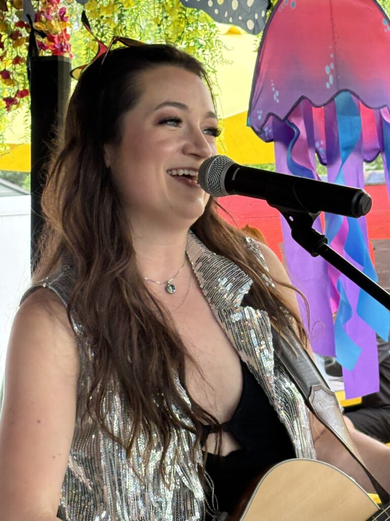 Singer performing with guitar on stage