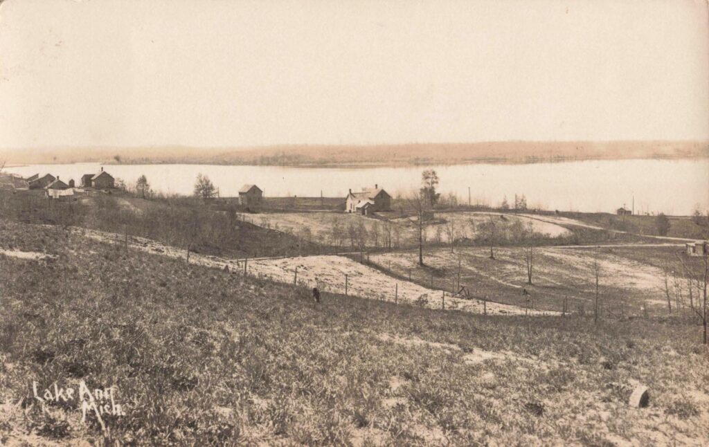 Historic landscape with lake and houses.