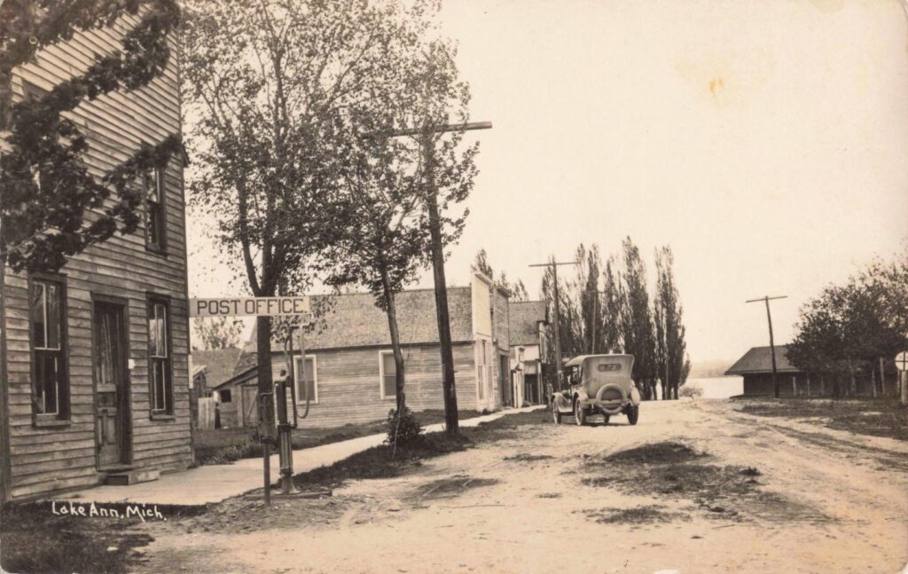 Lake Ann post office scene, showing the shift from horse-era village life to automobile travel.