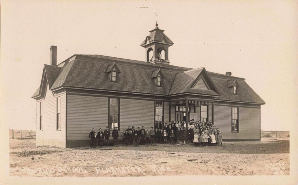 Children gather outside the Alabaster public school, a reminder that family life developed beside the quarry and mill.