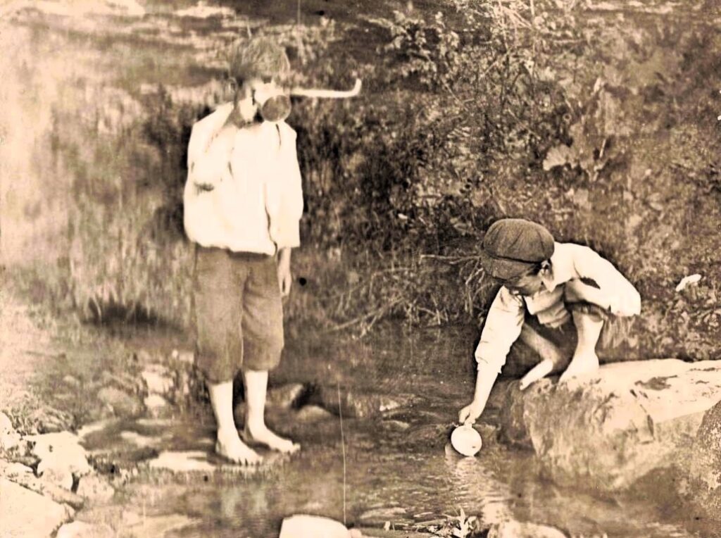 Two boys playing by a stream. - History of Concord Michigan