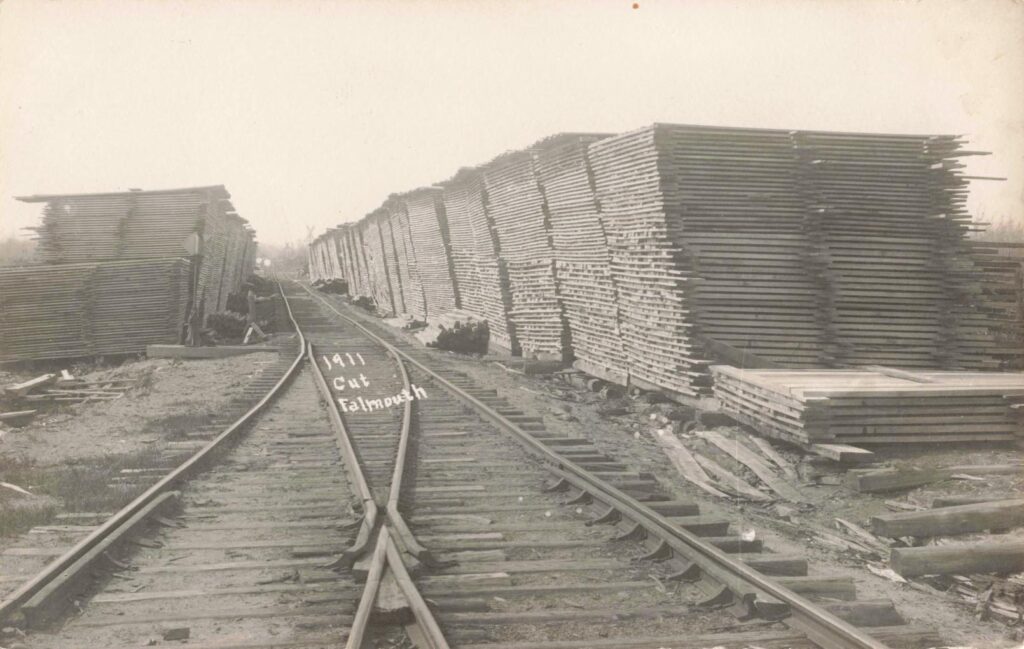 Lumber stacked along the rail line.