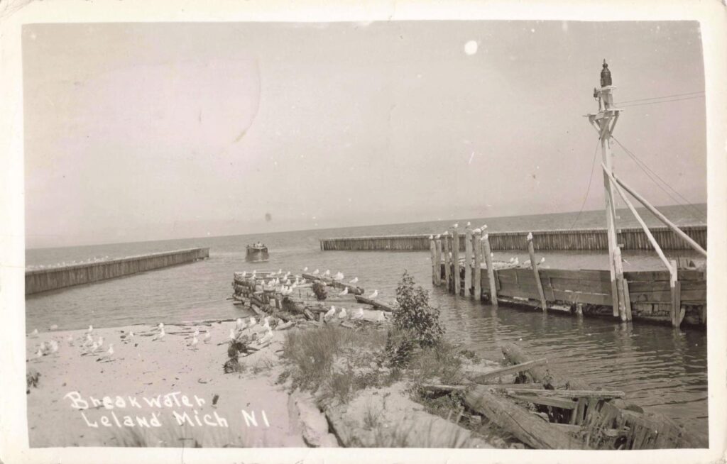 History of The Fishing Village of Leland Michigan - The 1939 breakwater view shows the working harbor where Lake Michigan, gulls and small boats met at the river mouth.