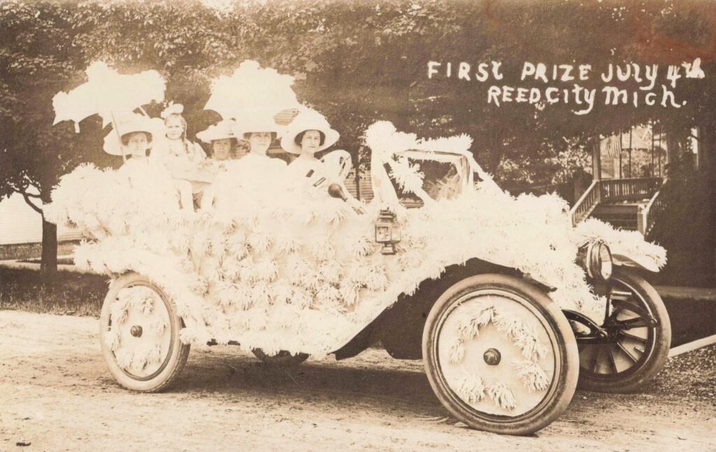 Women seated in a decorated prize-winning automobile during the Fourth of July celebration in Reed City Michigan in 1914