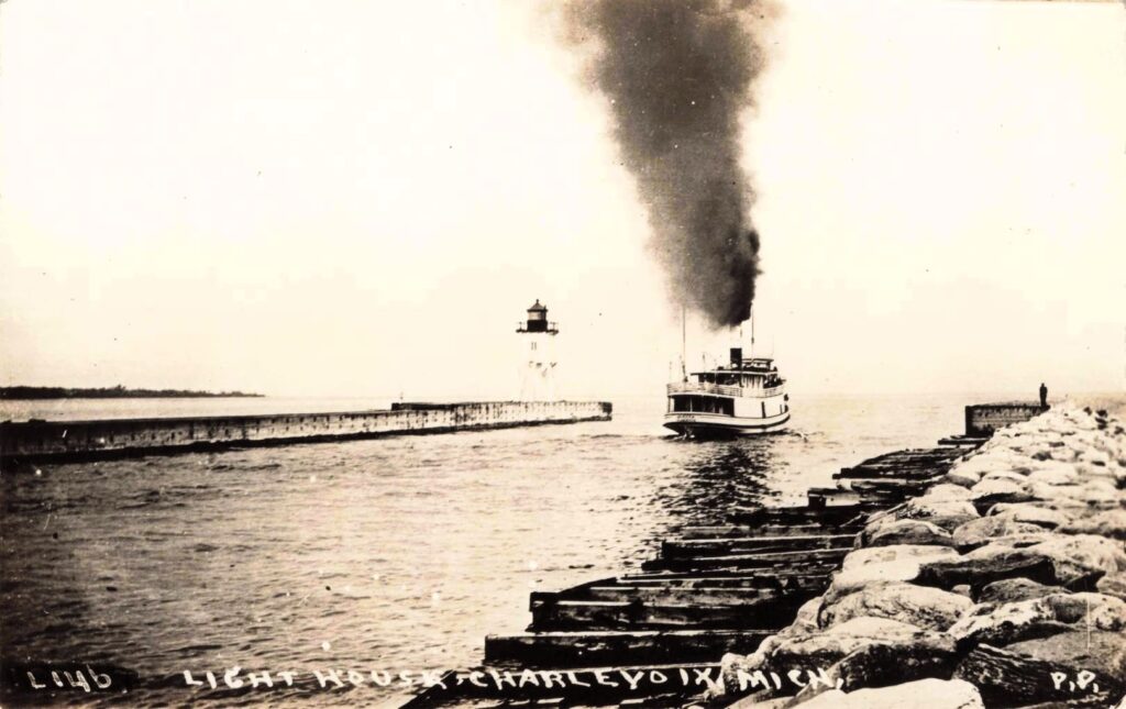 Boat approaching lighthouse on pier