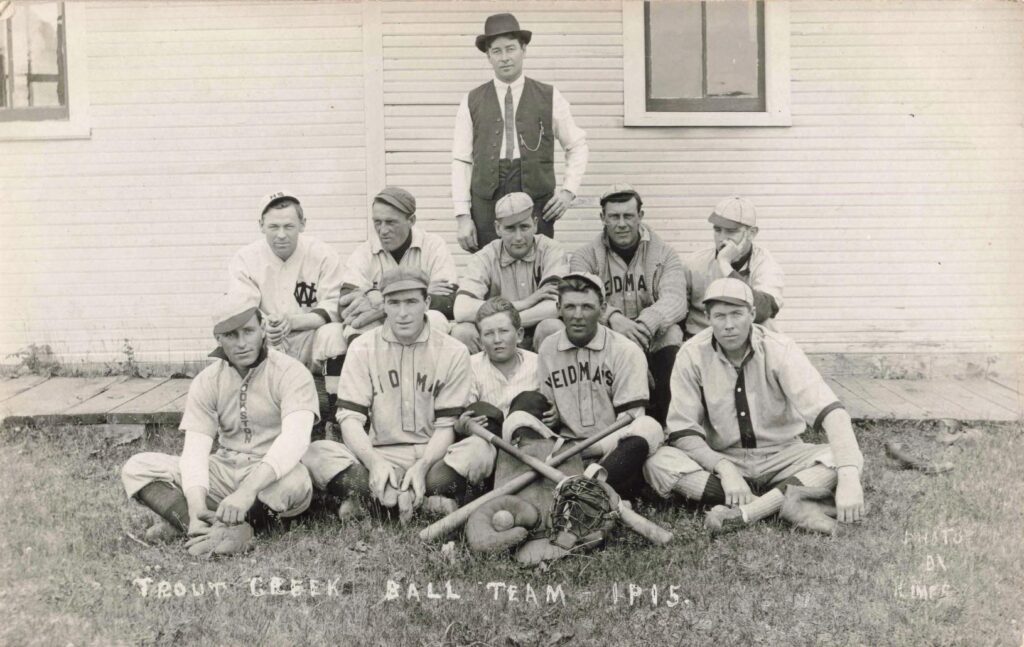 Trout Creek Michigan baseball players posing with bats and gloves in 1915.