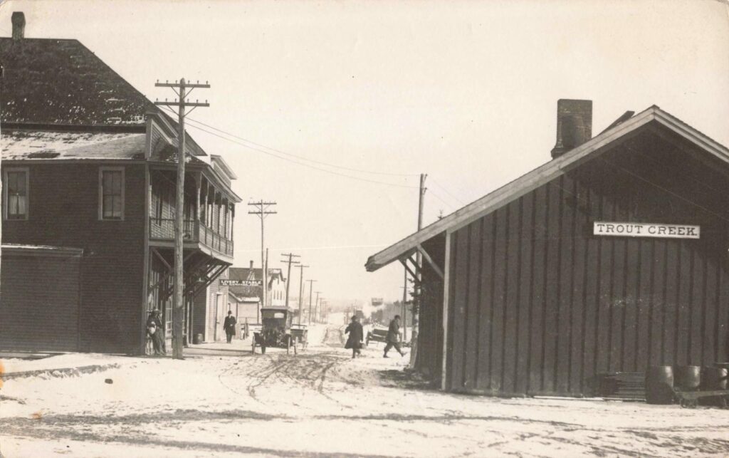 Trout Creek Michigan railroad depot, hotel and snowy street in 1915.