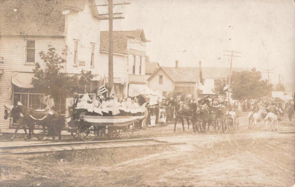 Horse-drawn wagon decorated for the Fourth of July parade in Beulah Michigan in 1908