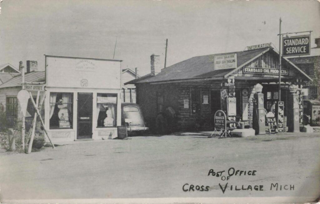 Historic postcard of the Cross Village post office and Standard service station with gas pumps and roadside signs.