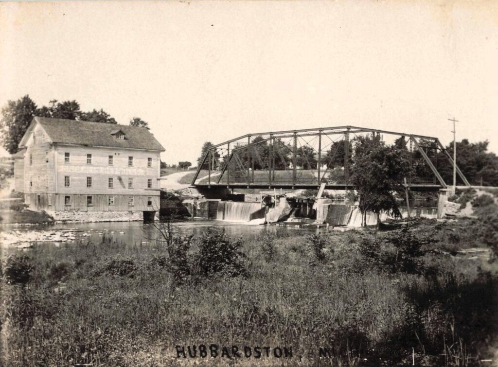 The grist mill stood beside the dam and bridge, placing flour production at the center of village traffic.
