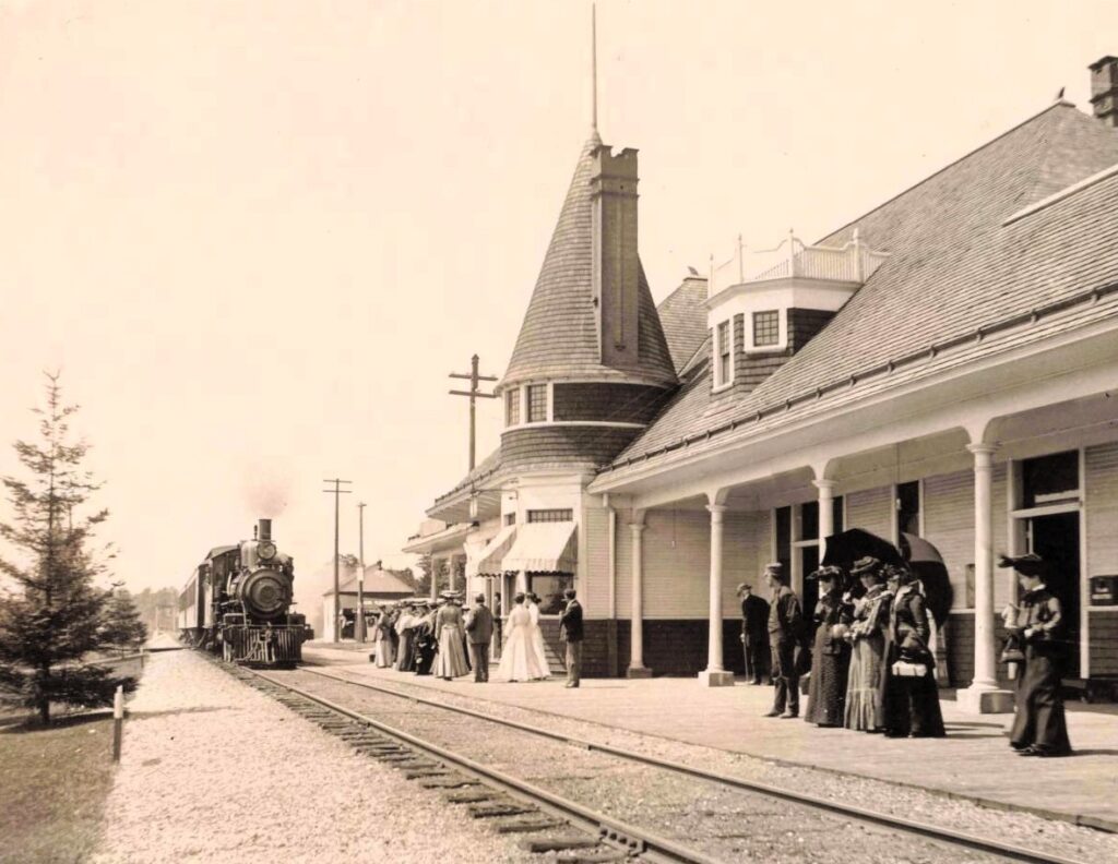 Historic train station with passengers waiting.