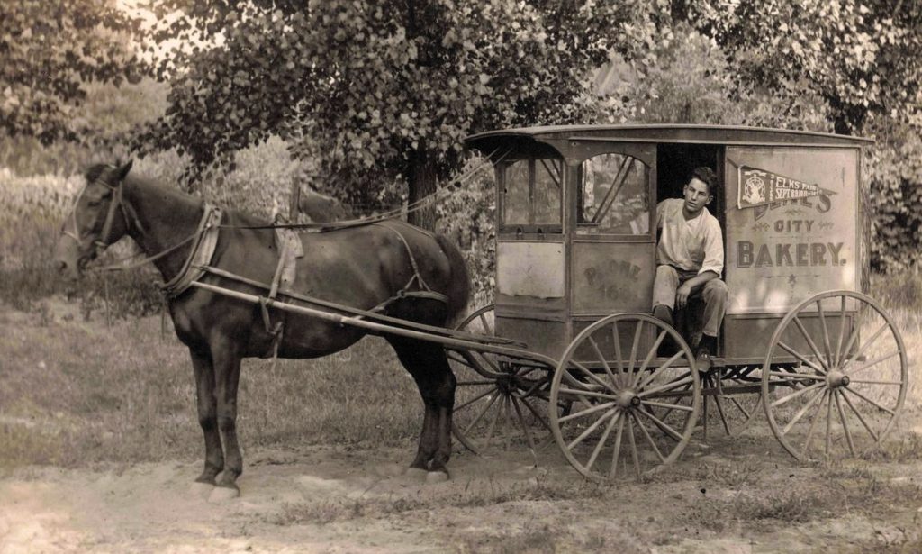 Horse-drawn bakery cart in countryside.