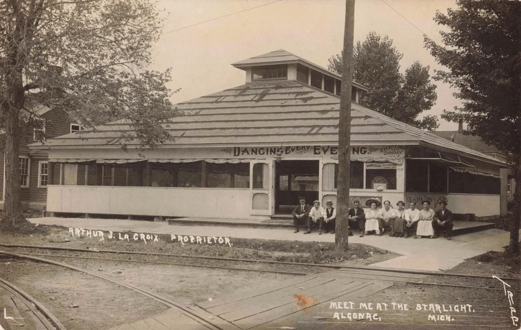 Historic dance hall with patrons outside.