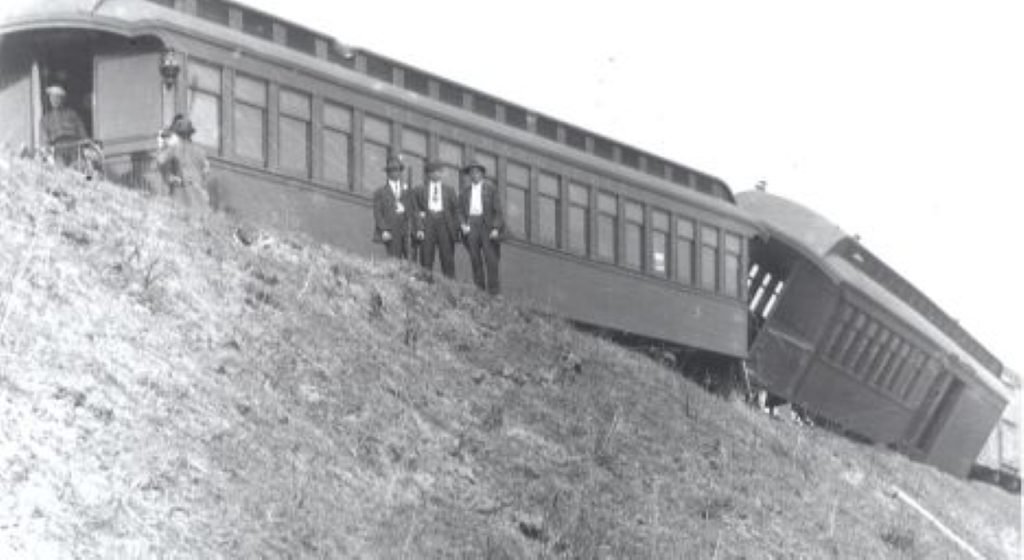 Derailed train on a hillside.