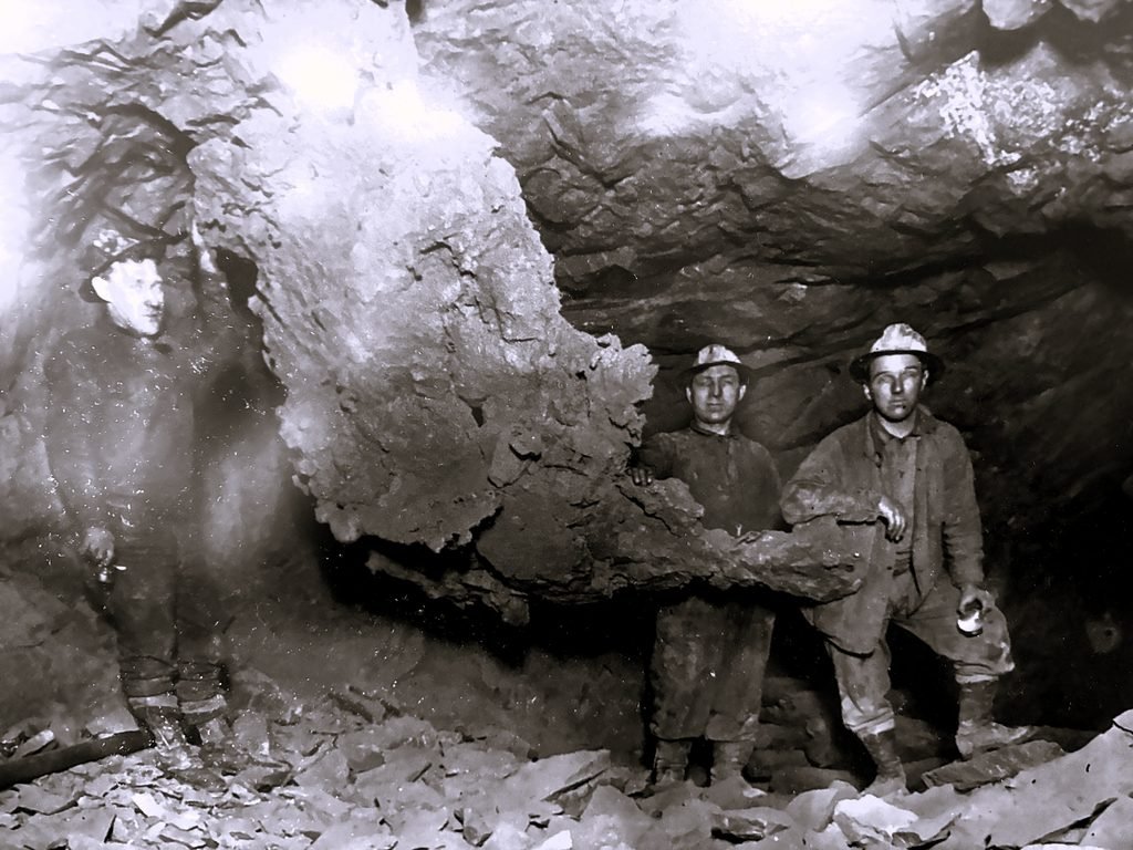 Workers beside large copper mass
