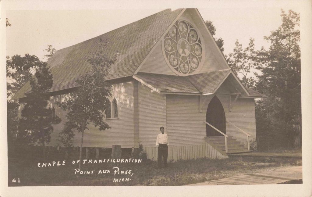 Historic postcard of the Church of the Transfiguration at Pointe Aux Pins, Michigan, showing its cross and large circular stained-glass window.